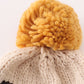 Black pompom dinosaur cable beanie